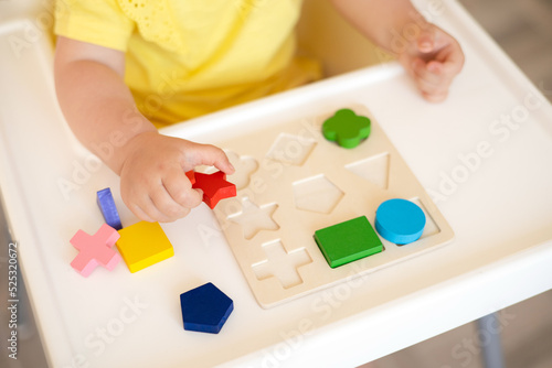 Close-up. Baby is playing. Infant learning and development. Wooden eco-friendly educational toys. Montessori system.