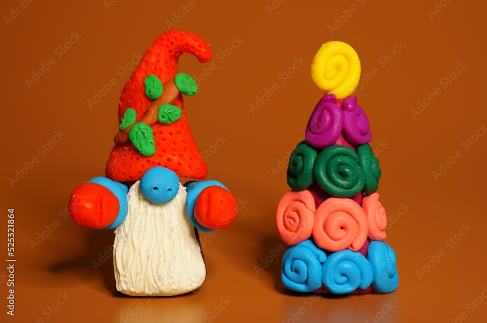A figure of a dwarf with a Christmas tree on a bright background. Christmas toys and decorations.