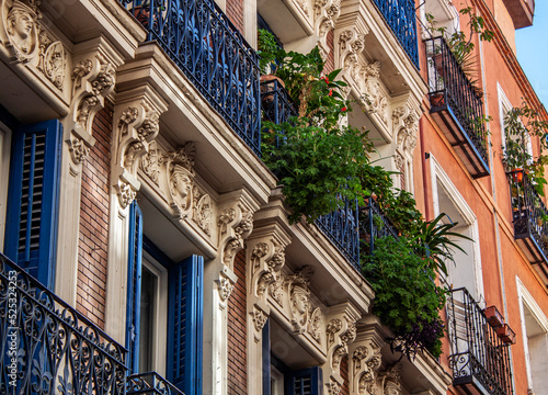 Exterior view of beautiful historical buildings in Madrid, Spain, Europe. Colorful Mediterranean urban street in the former Jewish quarter, Lavapiés, Embajadores neighborhood of the Spanish capital.