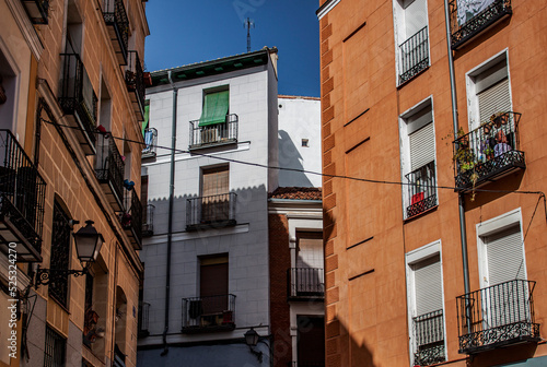 Exterior view of beautiful historical buildings in Madrid, Spain, Europe. Colorful Mediterranean urban street in the former Jewish quarter, Lavapiés, Embajadores neighborhood of the Spanish capital. photo