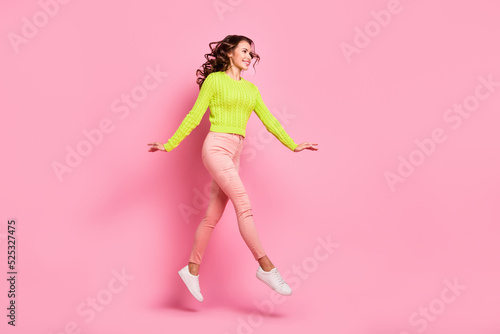 Full length profile photo of brunette lovely lady run wear green shirt trousers sneakers isolated on pink color background