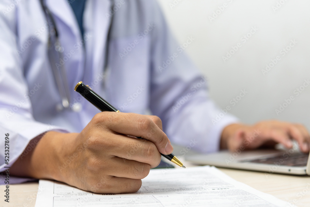 Doctor signs the patient paperwork at the desk.health care and insurance concept. Doctor signs the patient paperwork at the desk.health care and insurance concept.