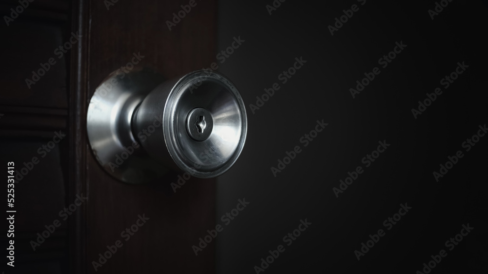 Close up of the keyhole of round door knob background. Slowly open the wooden door into a dark room in the house. Close up of the keyhole of round door knob background. Slowly open the wooden door into a dark room in the house.