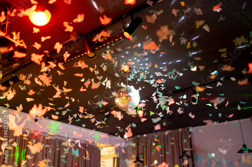 Disco-Kugel mit Lichtstrahlen und Papierschmetterlingen, Nachtparty-Hintergrundfoto