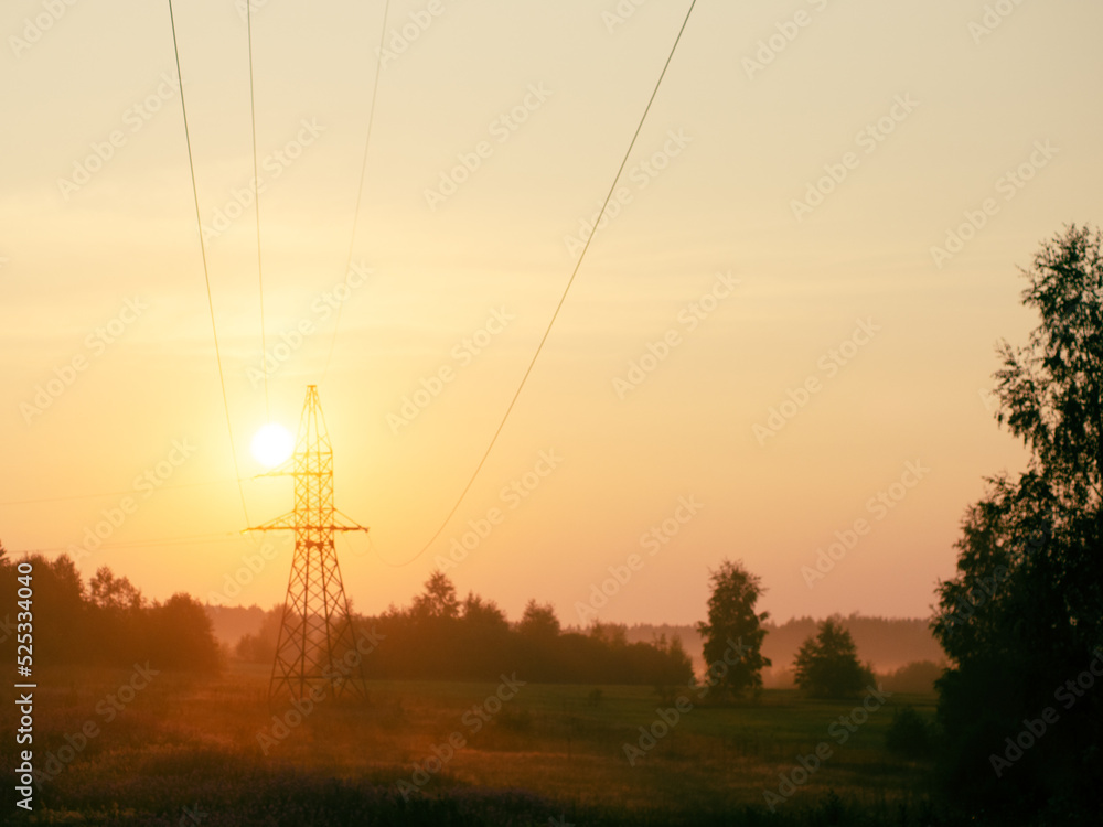 orange dawn with high voltage tower wires and nature