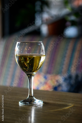 a glass of white wine on a wooden table 