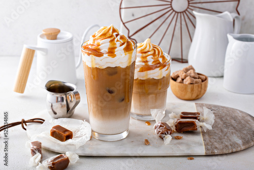 Iced caramel latte topped with whipped cream and caramel sauce photo