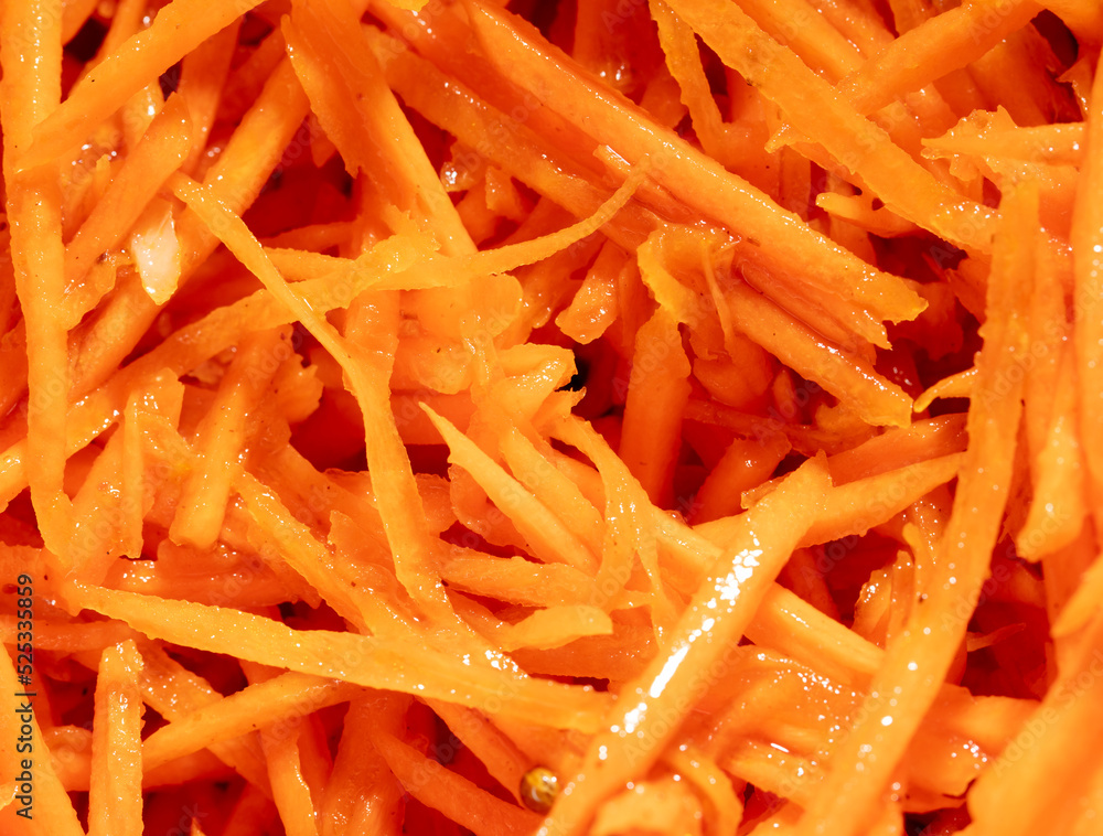 Orange peeled carrots in a salad as a background. Orange peeled carrots in a salad as a background.