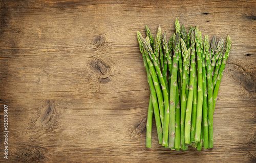 Green asparagus heap on wooden background. Copy space