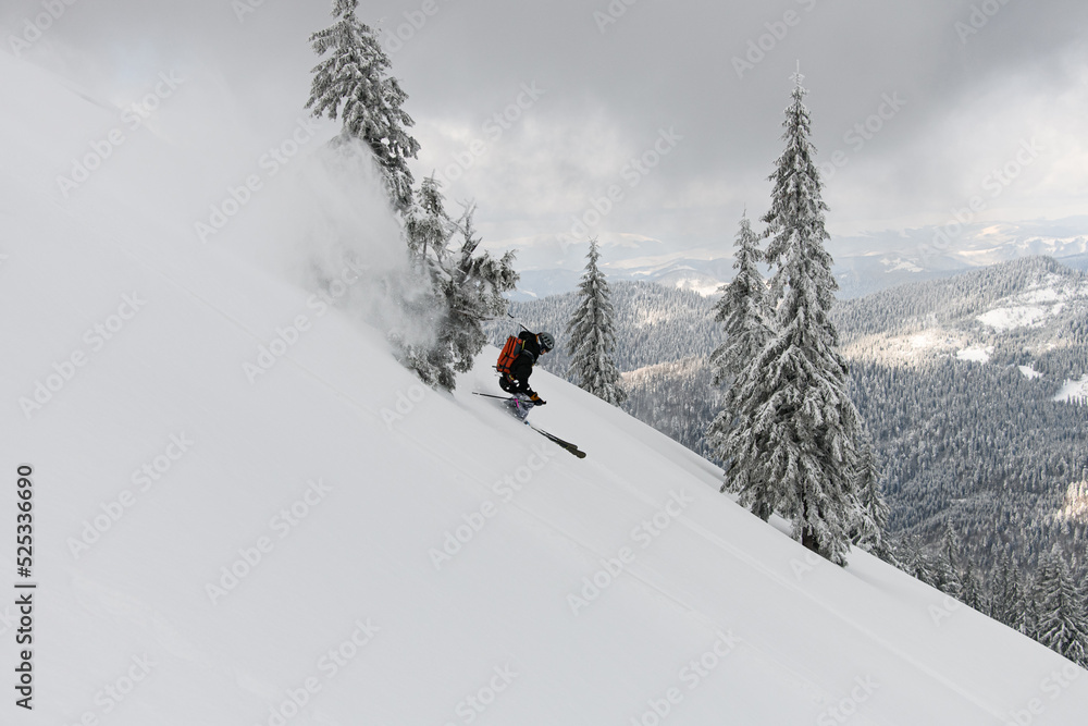 side view on skier riding on powder snow down the slope. Freeride skiing concept