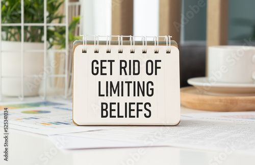 Get Rid Of Limiting Beliefs. text on wood table, on white paper photo