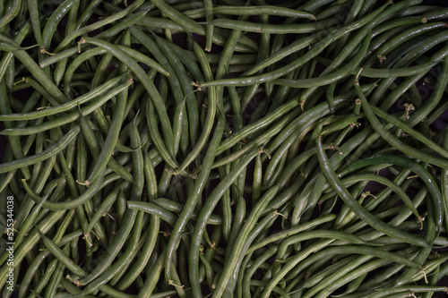 Green string beans close-up on a wooden table. Dark textured background