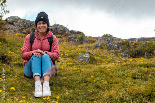 Atractiva mujer sentada en el césped después de una caminata y disfrutando de la hermosa naturaleza photo