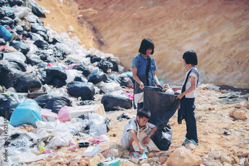 Poor children collecting garbage for sale Concept of pollution and Environment recycling old waste World Environment Day photo