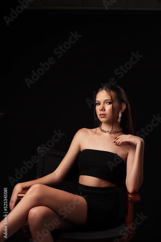 Portrait of a young girl on a dark background. Beauty, clean skin, stylish earrings