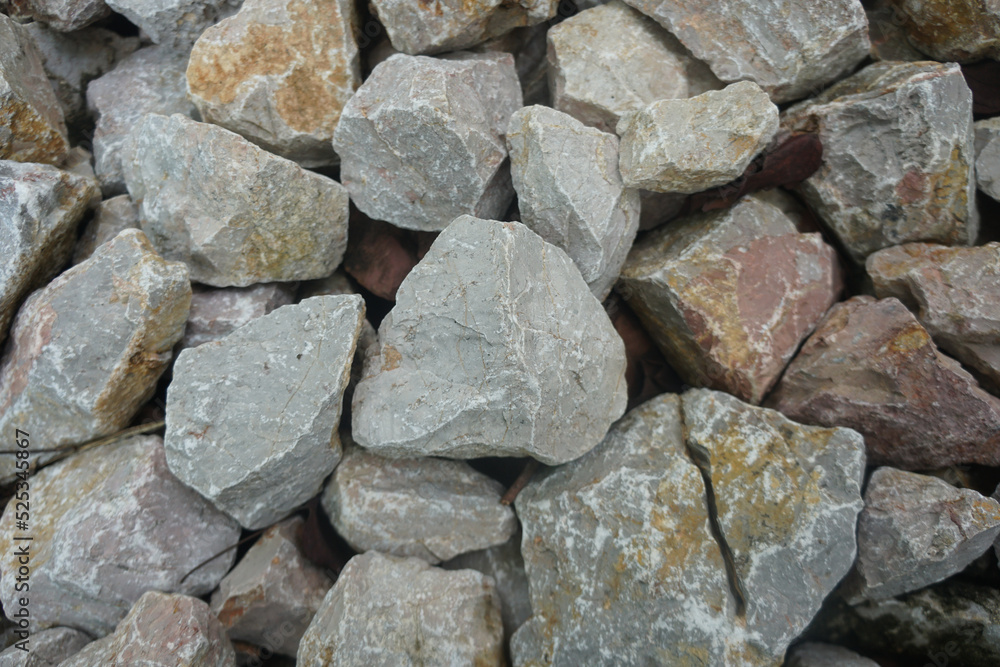 raw gray limestone carbonate sedimentary rock. A stone is used in the construction of houses, roads, buildings, or bridges. raw gray limestone carbonate sedimentary rock. A stone is used in the construction of houses, roads, buildings, or bridges.