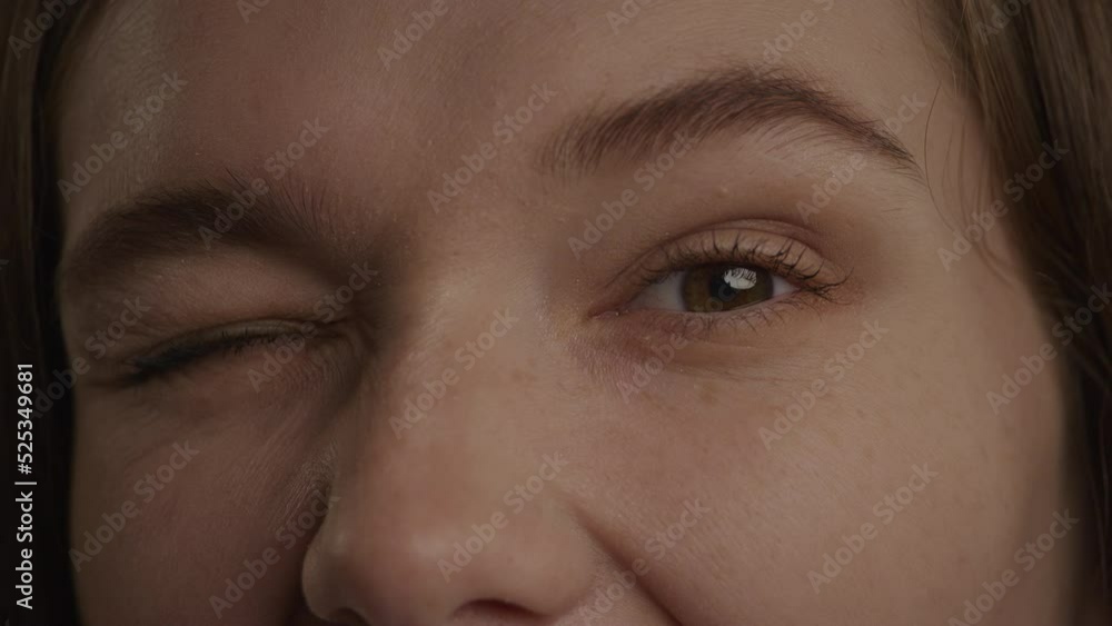 Close up of a caucasian woman eyes in a wink or blink gesture in slow motion Close up of a caucasian woman eyes in a wink or blink gesture in slow motion