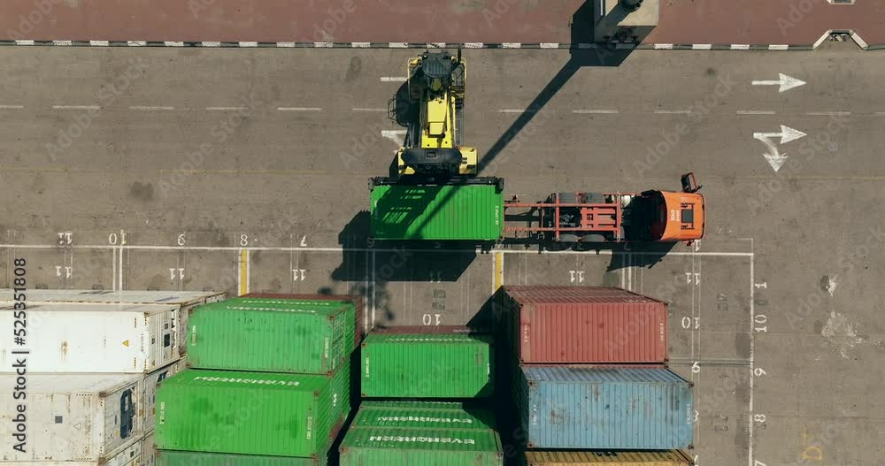 Container handler lifting a Green Shipping container off a truck and ...