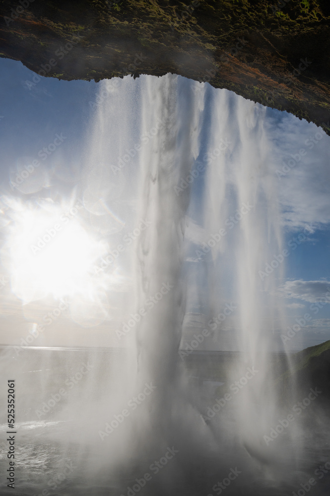 Behind the waterfall with the sun 