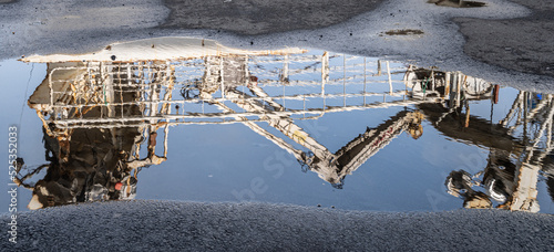 Reflection in a puddle of a crane structure.