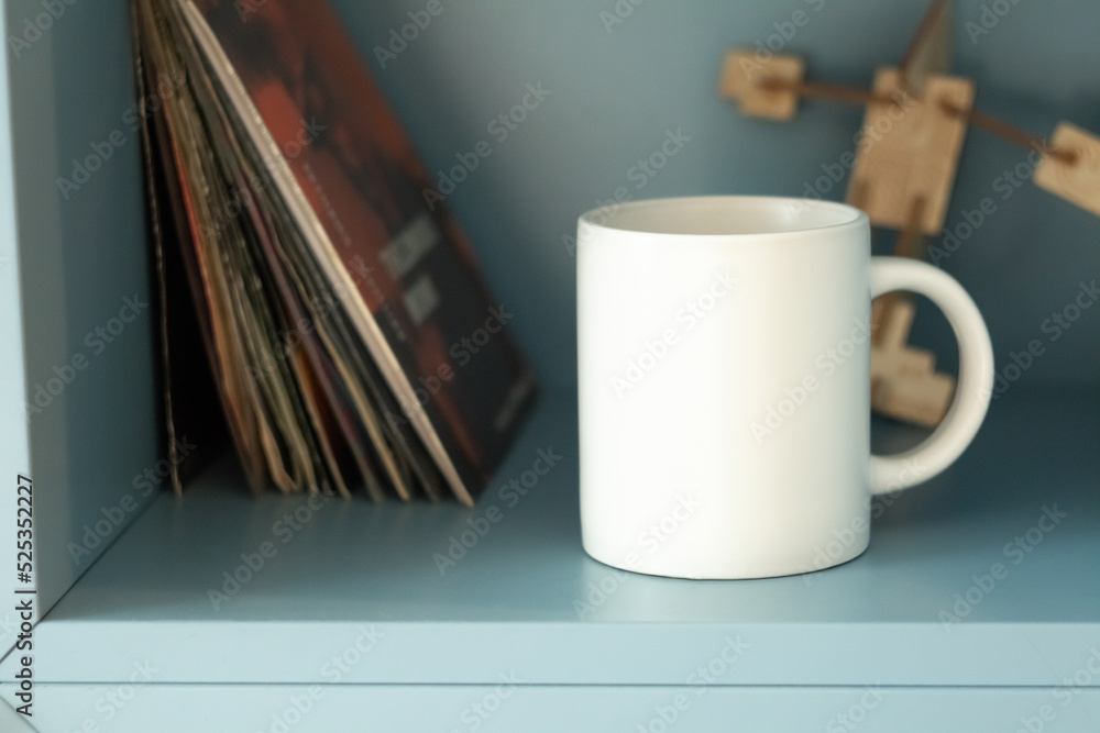 White mug on shelf with vinyls