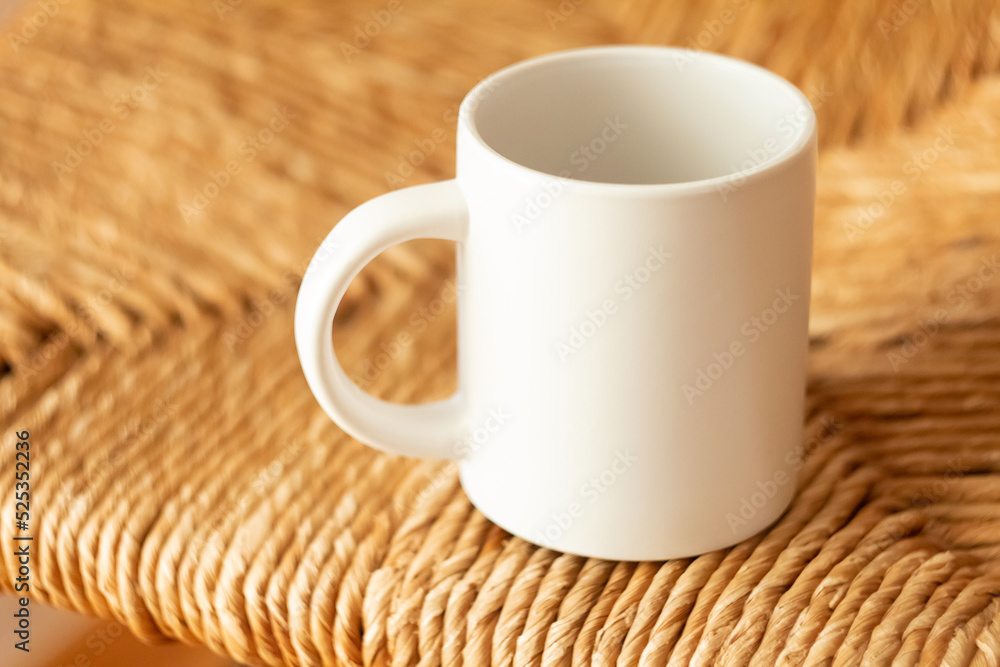A white mug on a wicker chair
