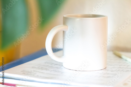 Obraz na płótnie A white mug on a stack of papers w salonie