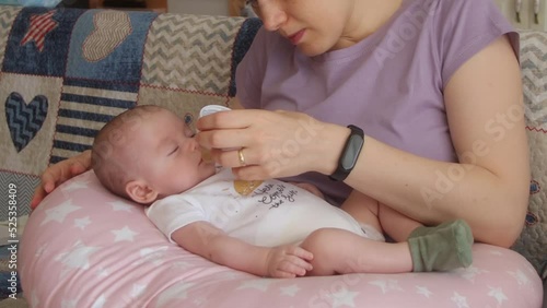 mom feeding her baby anti-reflux syrup with the bottle nipple
