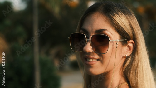Smiling girl in sunglasses posing at camera on the nature © Alexander