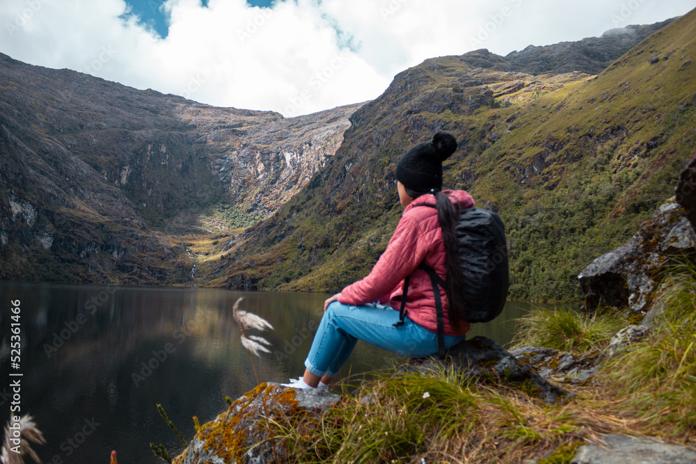 Naklejka premium Mujer reflexionando contra un lago rodeado de montañas