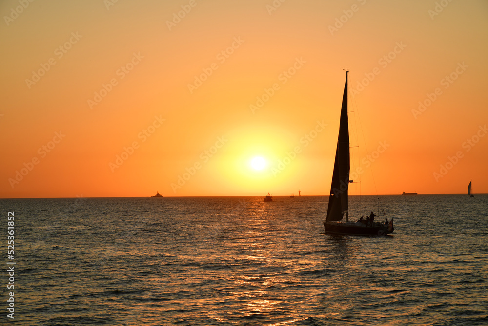 Yacht sailing against sunset. Holiday lifestyle landscape. 