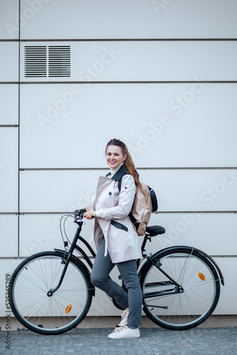 happy elegant woman with bicycle outside on city street