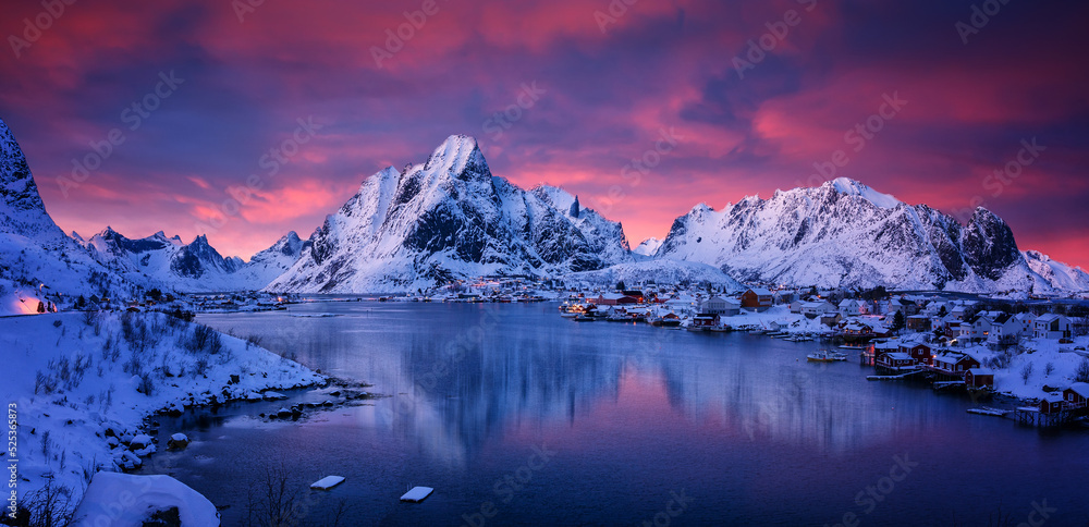 Scenic image of mountain landscape during sunset. Colorful sky over the snowcowered mountain and frozen fjord under vivid pink sunlight. Stunning nature background. Lofoten islands. North Norway.