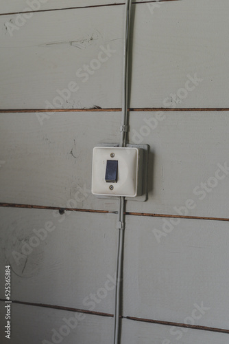 An old switch mounted on a wooden wall.