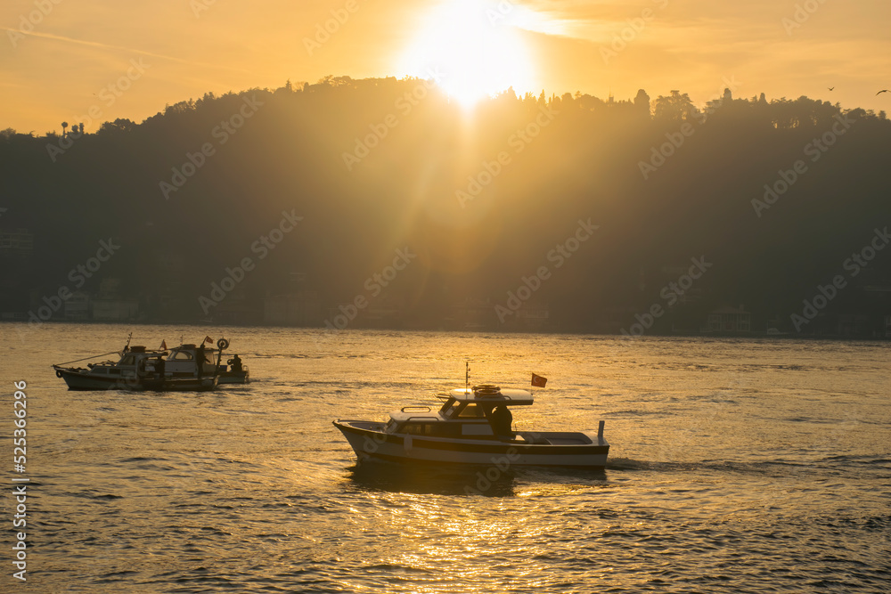 Naklejka premium Men on a boat in Bosphorus waters in Istanbul. Fisherman in boat in Istanbul. Turkish fisherman sailing in boat in sea.