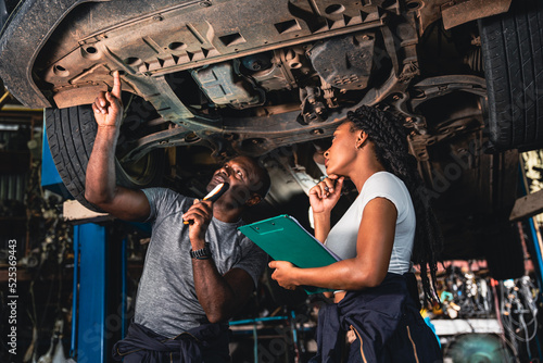 Two mechanic was checking the car suspension.
