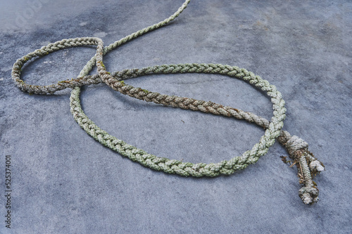 Metal background and texture of a long old hemp twisted rope in an infinite loop shape. Wallpaper gray.