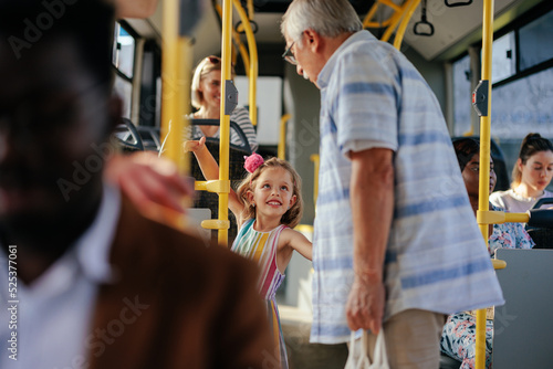 Grandfather and granddaughter in public transport