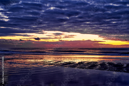 Sunset at the ocean  with the sky reflecting in the water. Egmond aan Zee  Netherlands.