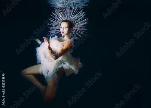 Beautiful woman with red lips and in women's jewellery underwater as the Virgin Mary