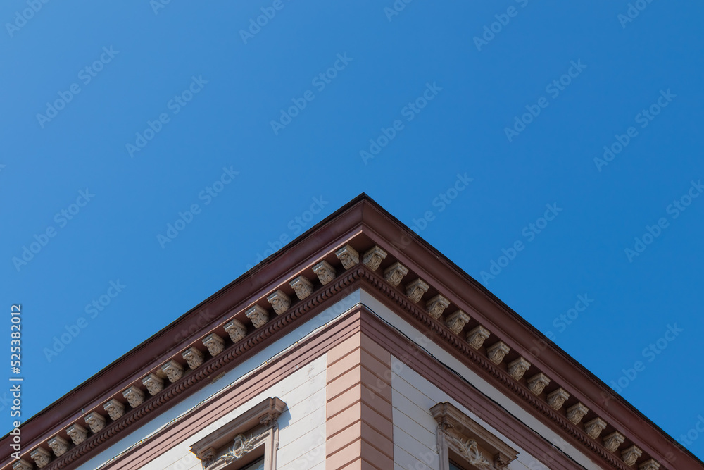 Corner of an old house with beautiful architecture against a blue clear sky during the day. Free space for text
