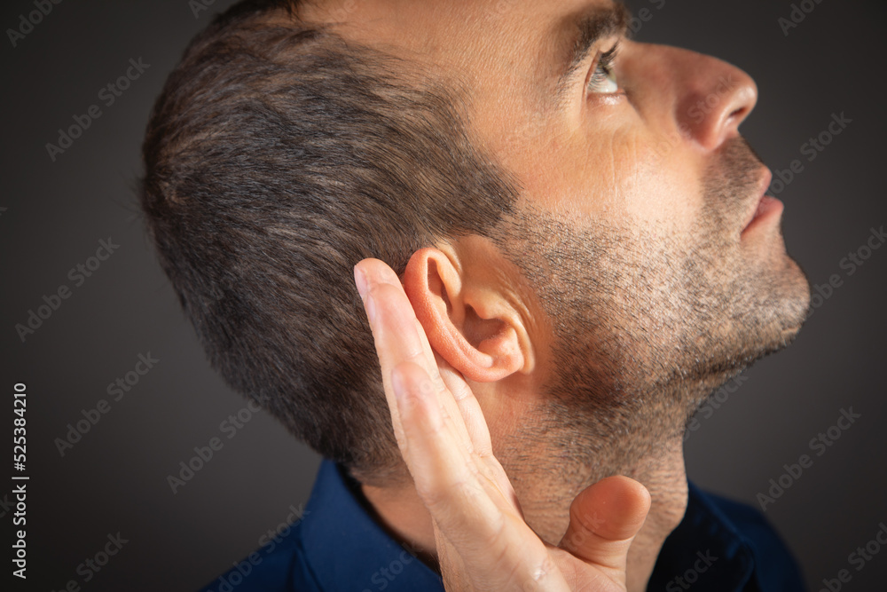 Fototapeta premium Caucasian man hold hand near ear. Trying to hear a gossip