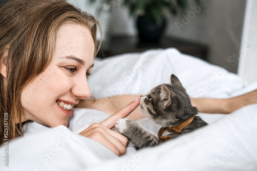 Cat Adoption, Adopt kitten from rescues and shelters. Rehome a Cat. Portrait of woman playing with outbred homeless adopted grey kitten photo