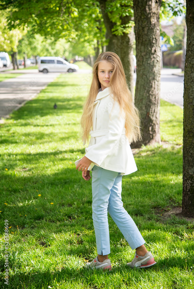 portrait of a little beautiful girl with long blond hair in the green park on sunny spring day portrait of a little beautiful girl with long blond hair in the green park on sunny spring day