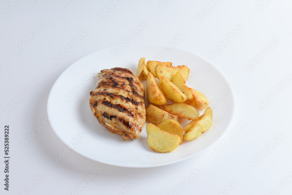 Tasty grilled chicken fillets on white plate with potatoes. Isolated on white background, top view