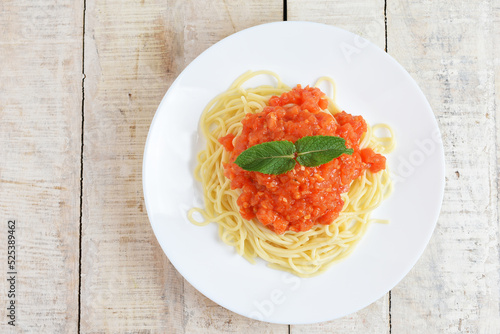 Classical spaghetti with tomato sauce on wooden table. Copy space for text
