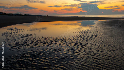 Distant person across the tidal flats at Hilton Head Island  SC at sunrise.