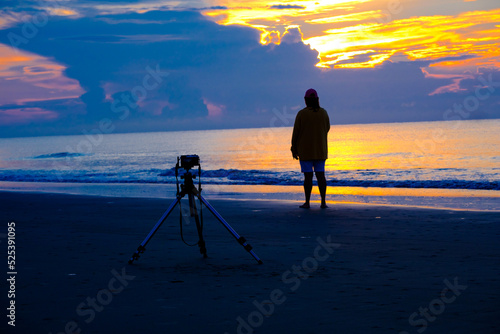 person standing beside camera on tripod at a beach sunrise in South Carolina, 