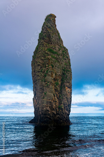 seascape of Kunashir, ocean shore with a huge vertical rock in the water