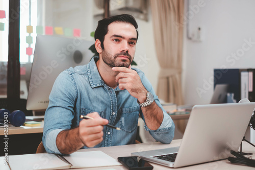  Young businessman with digital laptop in office. Cheerful casual caucasian employee. Portrait of confident modern young businessman hand holding digital tablet.